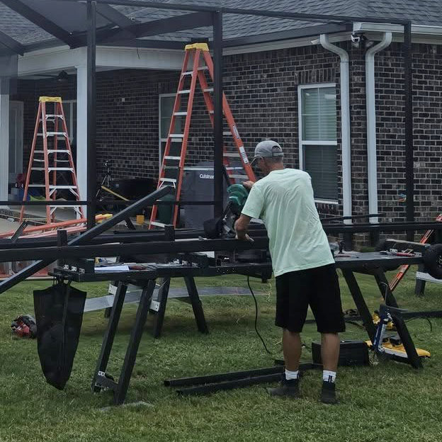 Crew installing a screened enclosure on a sunny day