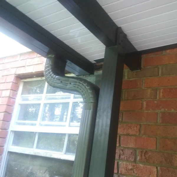 Aluminum carport covering a driveway and parked vehicles